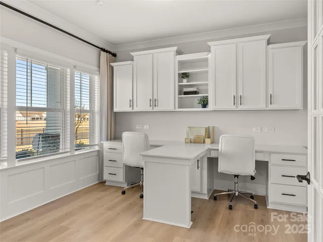 a view of workspace with wooden floor and white cabinet