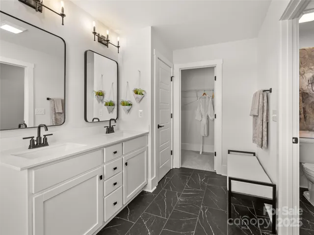 a spacious bathroom with double vanity and mirrors