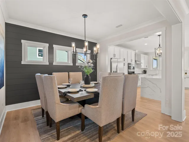 a dining room with furniture a chandelier and wooden floor