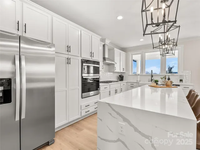 a large kitchen with stainless steel appliances cabinets a sink and a counter top space