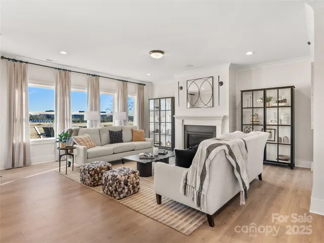 a living room with furniture large window and wooden floor