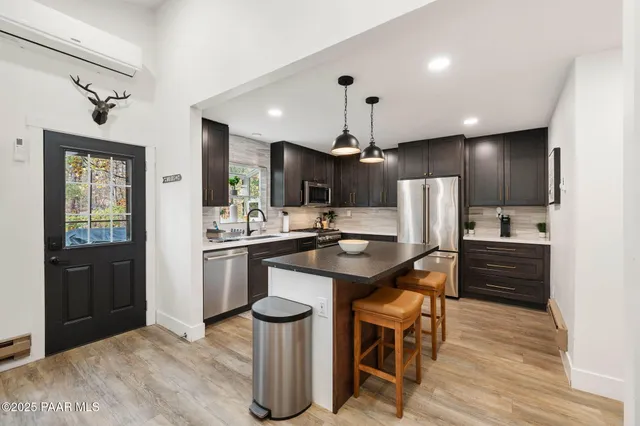 a kitchen with stainless steel appliances granite countertop a stove and a wooden floors