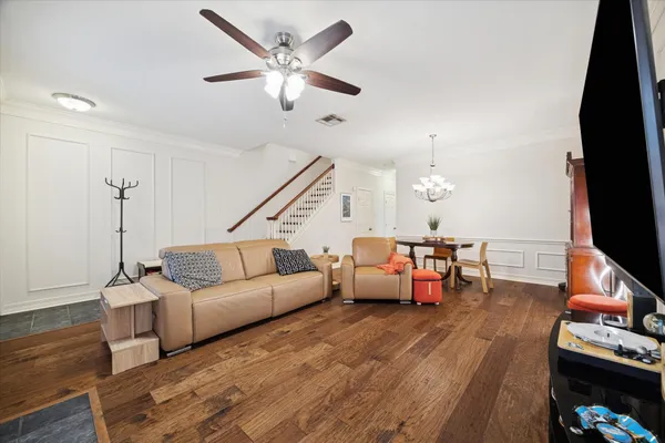 a view of a dining room with furniture a chandelier and wooden floor