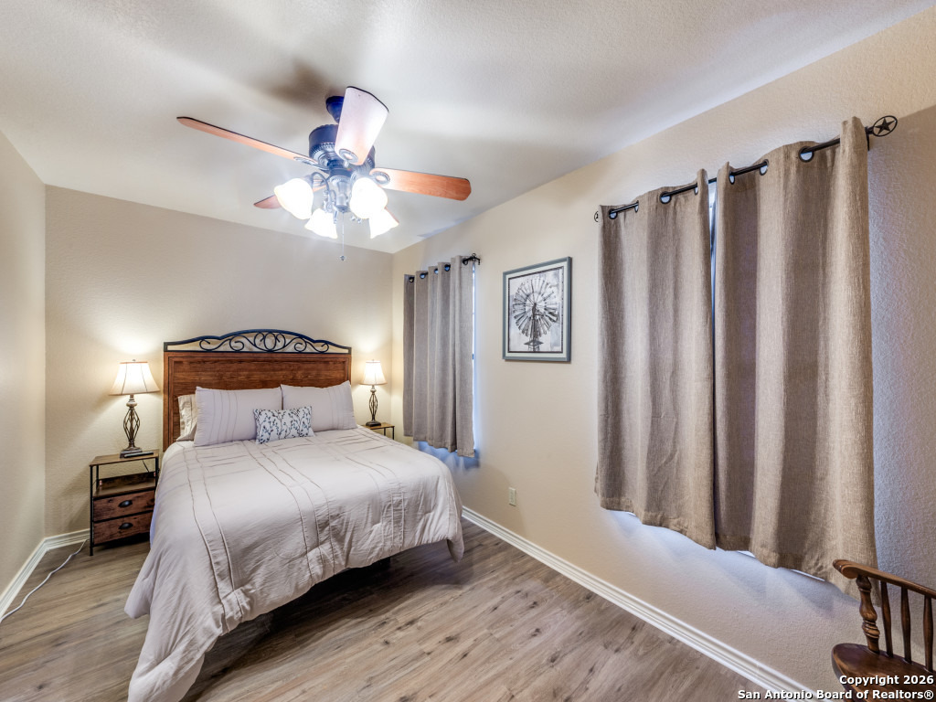 6472 Bluntzer Road Jourdanton, TX 78026 - Photo 11 of 45 a bedroom with a bed and a chandelier