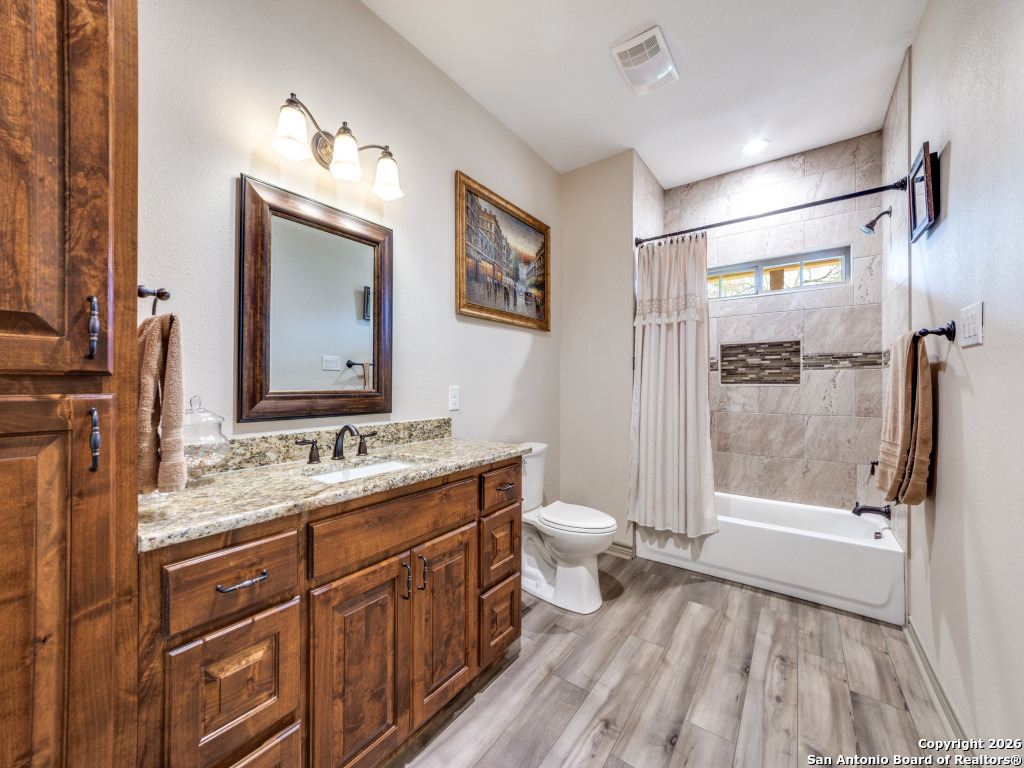 6472 Bluntzer Road Jourdanton, TX 78026 - Photo 14 of 45 a bathroom with a sink a toilet a mirror and shower