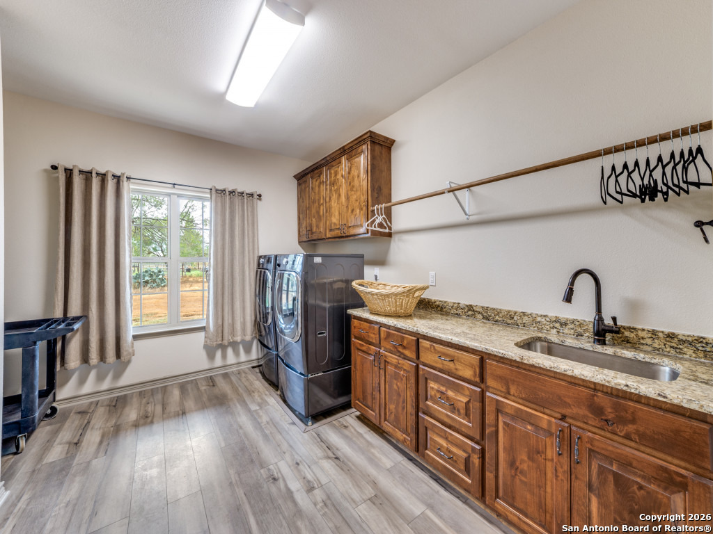 6472 Bluntzer Road Jourdanton, TX 78026 - Photo 15 of 45 a kitchen with stainless steel appliances granite countertop a stove a sink dishwasher and a refrigerator with wooden floor