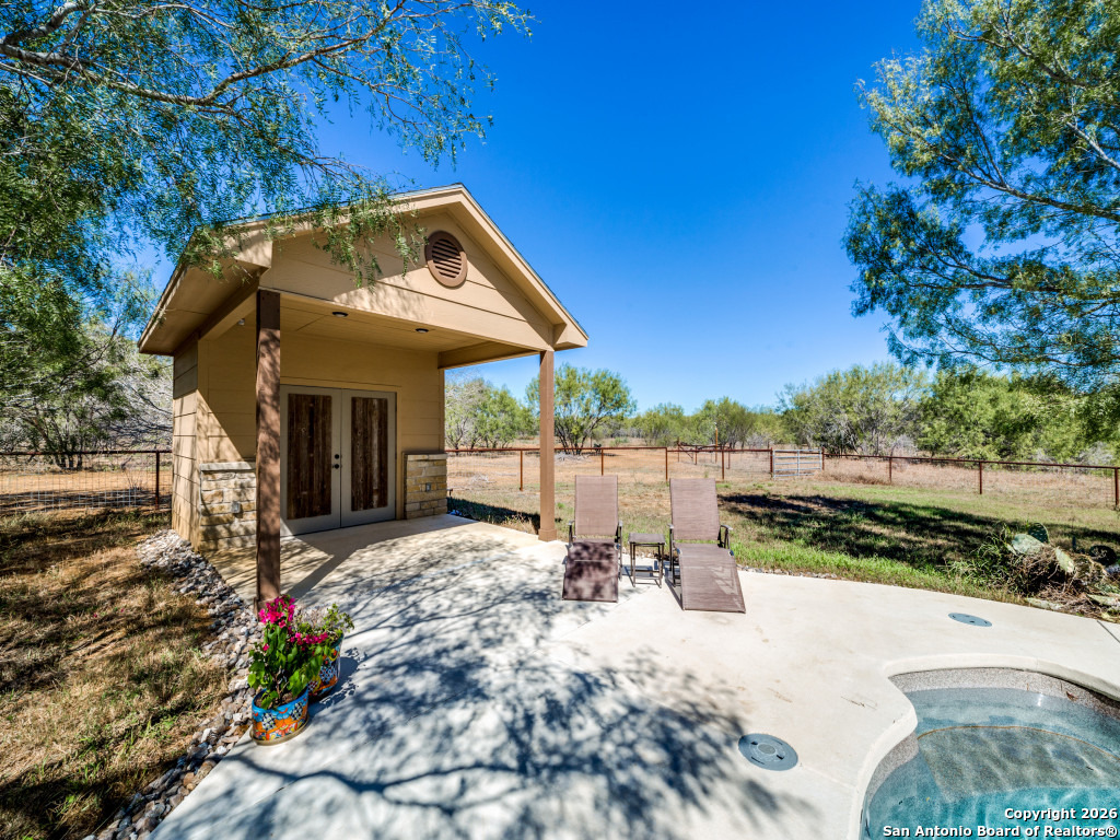 6472 Bluntzer Road Jourdanton, TX 78026 - Photo 20 of 45 a view of a patio with table and chairs potted plants with wooden fence
