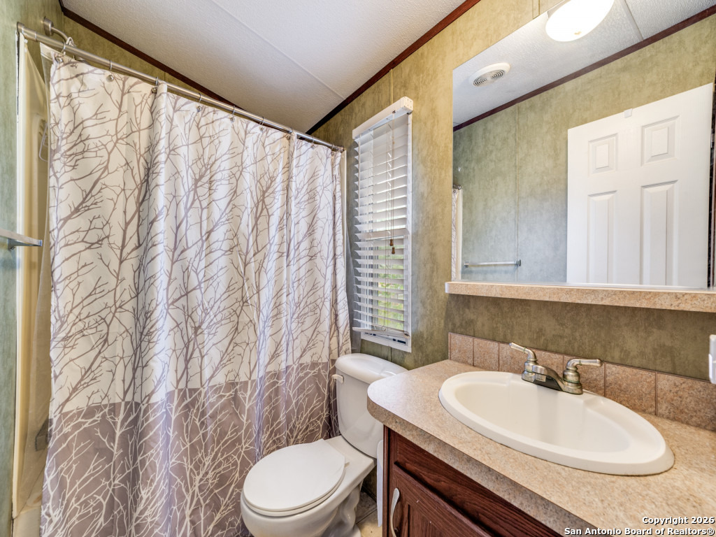 6472 Bluntzer Road Jourdanton, TX 78026 - Photo 32 of 45 a bathroom with a sink a toilet and tub