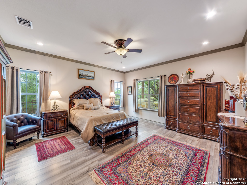 6472 Bluntzer Road Jourdanton, TX 78026 - Photo 9 of 45 a spacious bedroom with a bed dresser and a rug