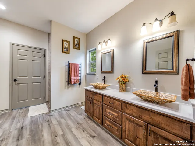 a en suite bathroom with a granite countertop sink and a mirror