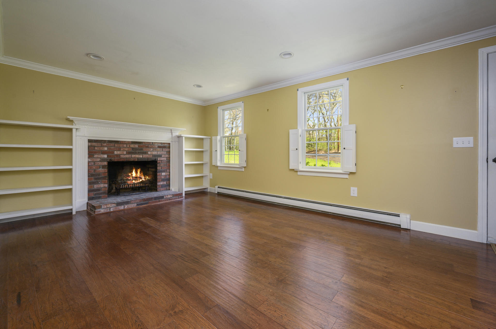 129 Richardson Road Centerville, MA 02632 - Photo 5 of 24 a view of an empty room with wooden floor fireplace and a window