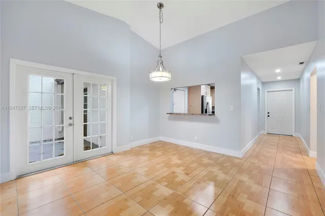 a view of empty room with wooden floor and windows