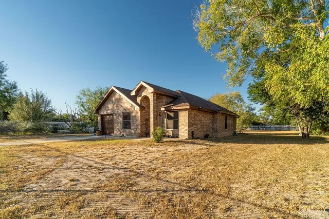 a front view of house with yard and trees around