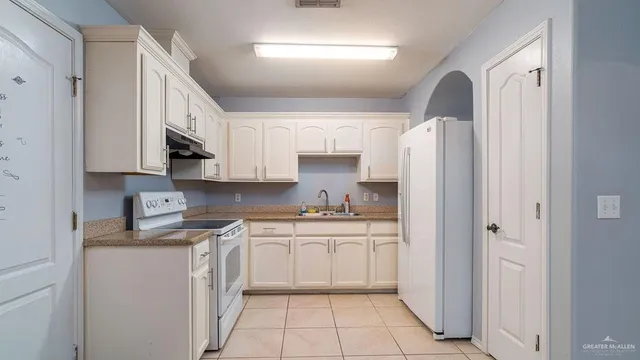 a kitchen with stainless steel appliances a refrigerator sink and cabinets