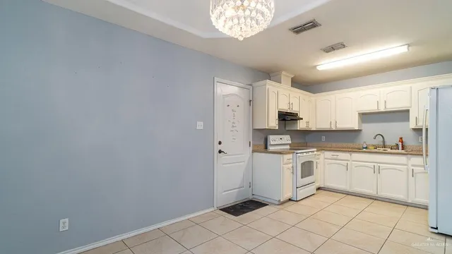 a kitchen with white cabinets and appliances