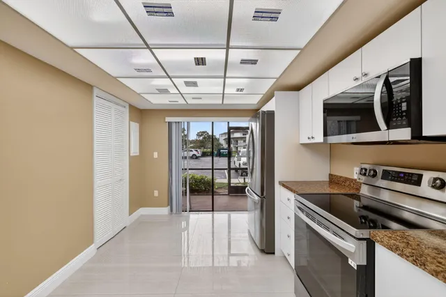 a kitchen with stainless steel appliances granite countertop a refrigerator a stove a microwave oven with a sink and dishwasher