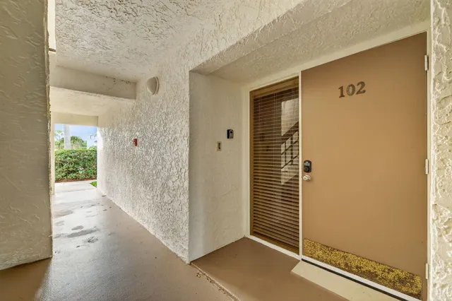 a view of a hallway with wooden floor and a cabinet