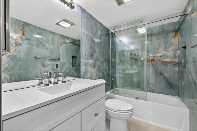 a bathroom with a sink mirror toilet and bathtub