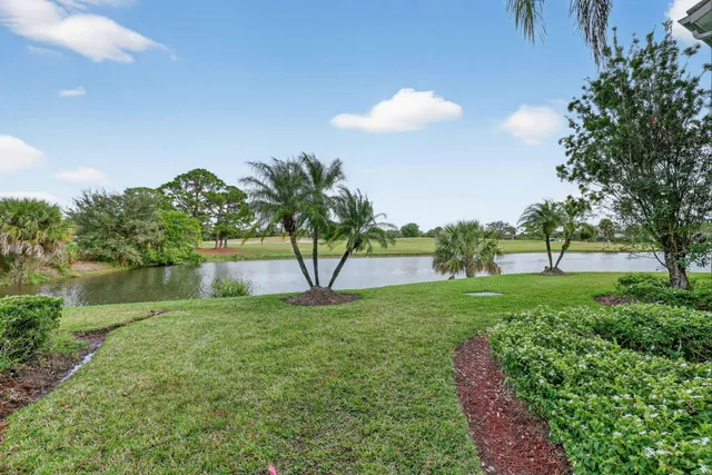 a front view of a house with a yard and potted plants