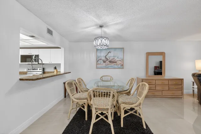 a dining room with furniture a chandelier and wooden floor