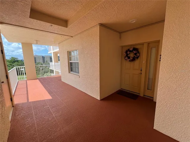 a view of a hallway with wooden floor and a potted plant