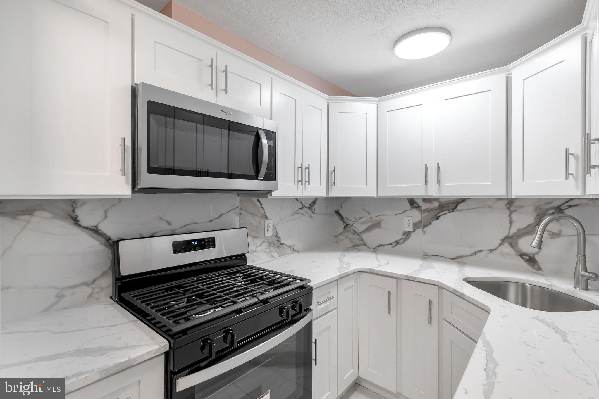 198 Sherbrook Boulevard Upper Darby, PA 19082 - Photo 12 of 30 a kitchen with stainless steel appliances granite countertop white cabinets and white stove top oven with granite countertops