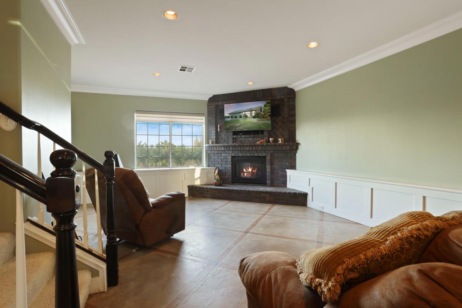18050 North Tretheway Road Lodi, CA 95240 - Photo 27 of 37 a living room with furniture a flat screen tv and a fireplace