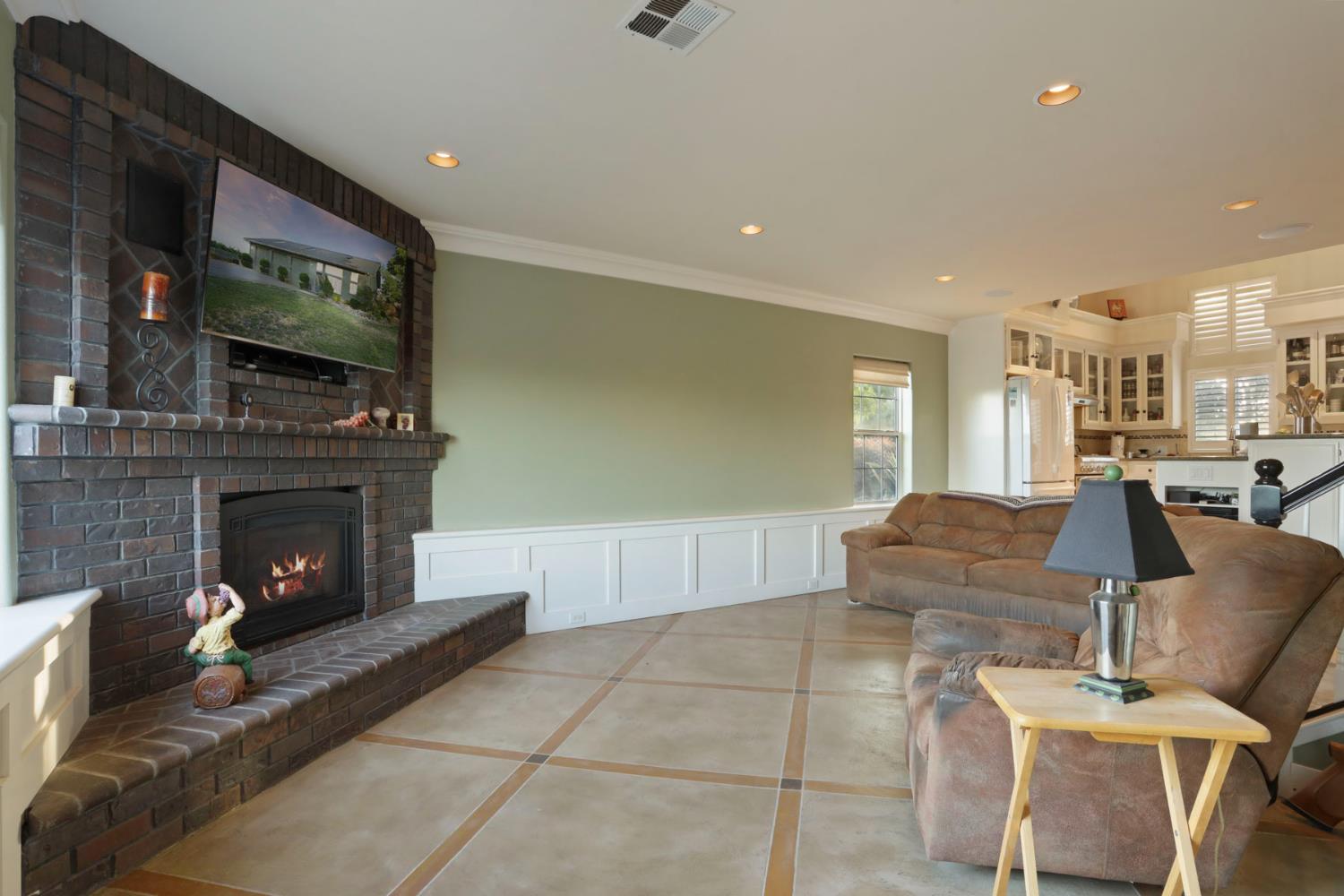 18050 North Tretheway Road Lodi, CA 95240 - Photo 28 of 37 a living room with furniture a flat screen tv and a fireplace