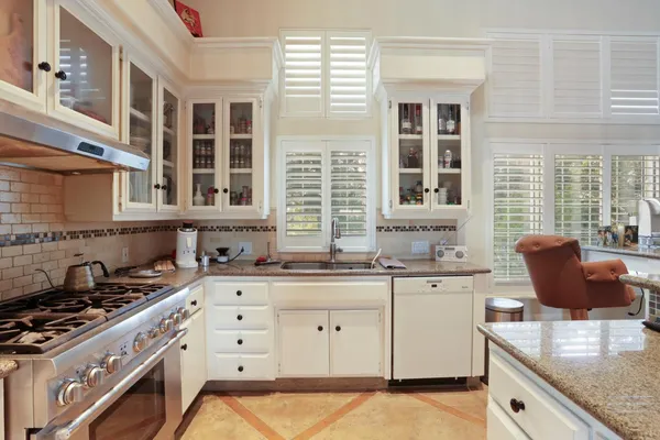 a living room with furniture kitchen view and a chandelier