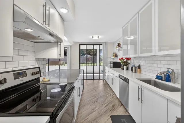 a large kitchen with lots of counter space and wooden floor