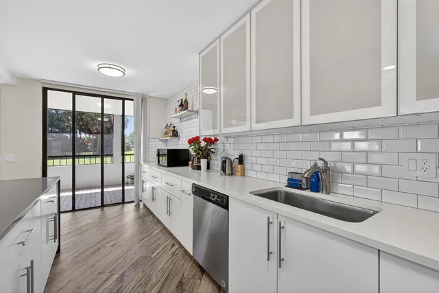 a kitchen with stainless steel appliances a sink a stove a refrigerator and cabinets