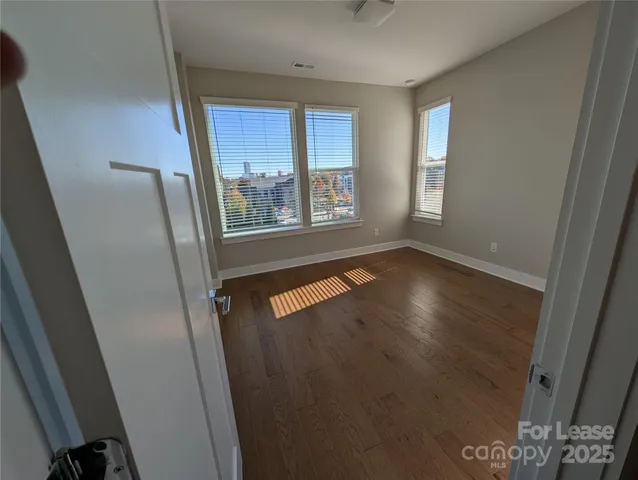 a view of an empty room with wooden floor