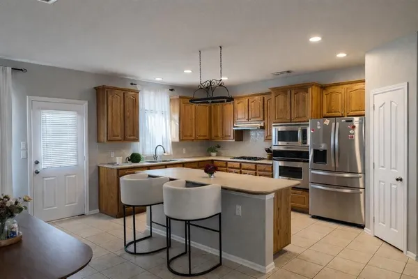 a kitchen with granite countertop a sink appliances cabinets and furniture