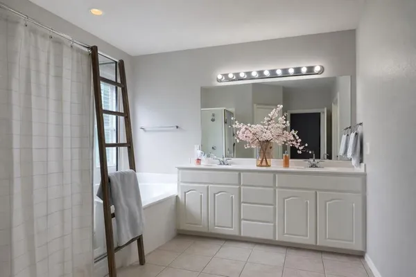 a spacious bathroom with a double vanity sink and a mirror