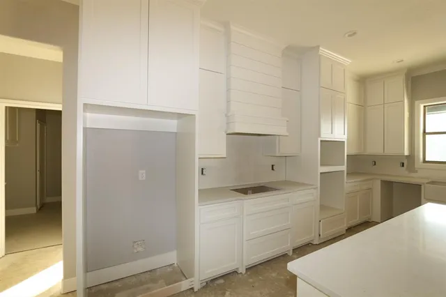 a kitchen with a refrigerator stove and white cabinets