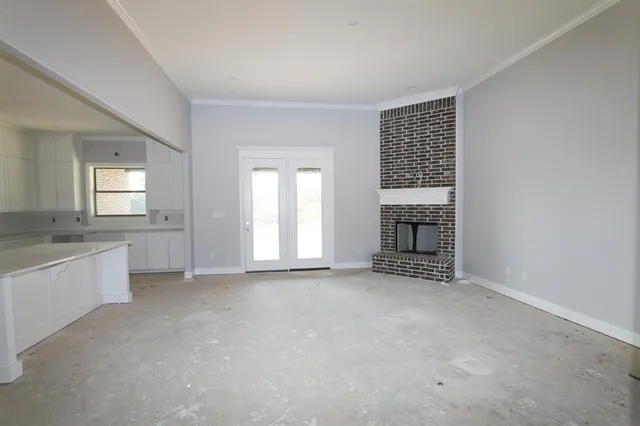 an empty room with windows and fireplace