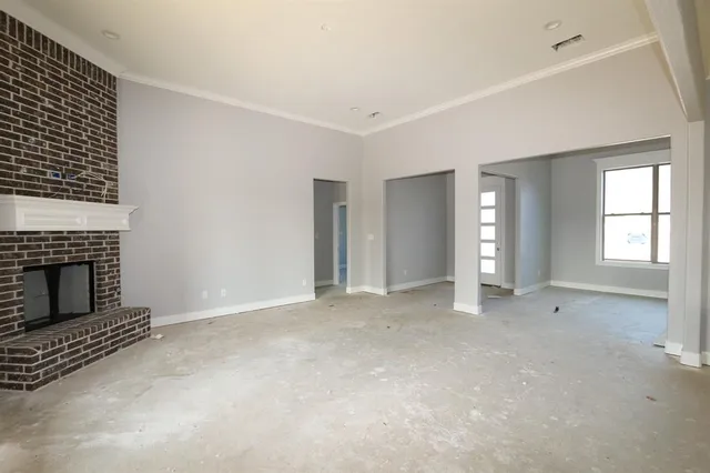 an empty room with windows and fireplace