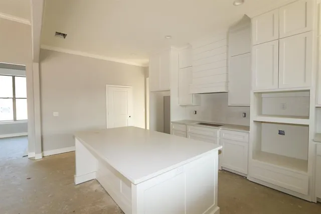 a kitchen with a refrigerator and white cabinets