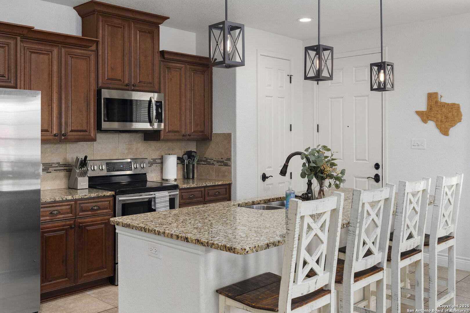 1608 Lake Ridge Boulevard Canyon Lake, TX 78133 - Photo 12 of 46 a kitchen with stainless steel appliances granite countertop a stove top oven a refrigerator a sink and dishwasher