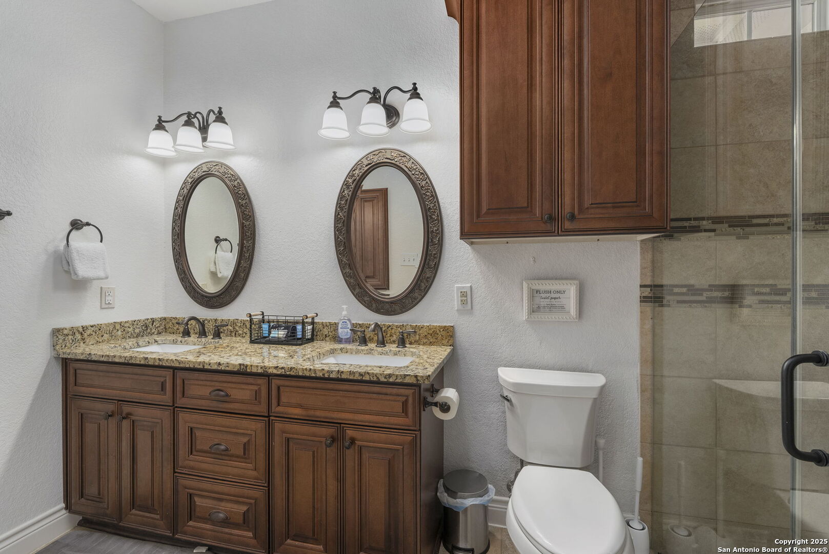 1608 Lake Ridge Boulevard Canyon Lake, TX 78133 - Photo 26 of 46 a bathroom with a toilet a sink and a mirror