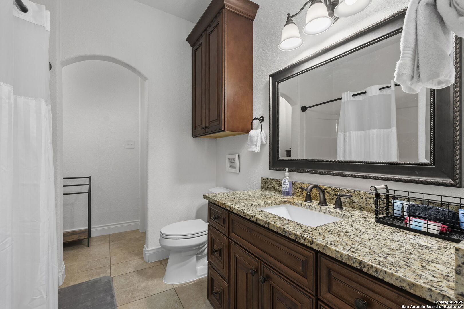1608 Lake Ridge Boulevard Canyon Lake, TX 78133 - Photo 27 of 46 a bathroom with a granite countertop sink a toilet and a mirror