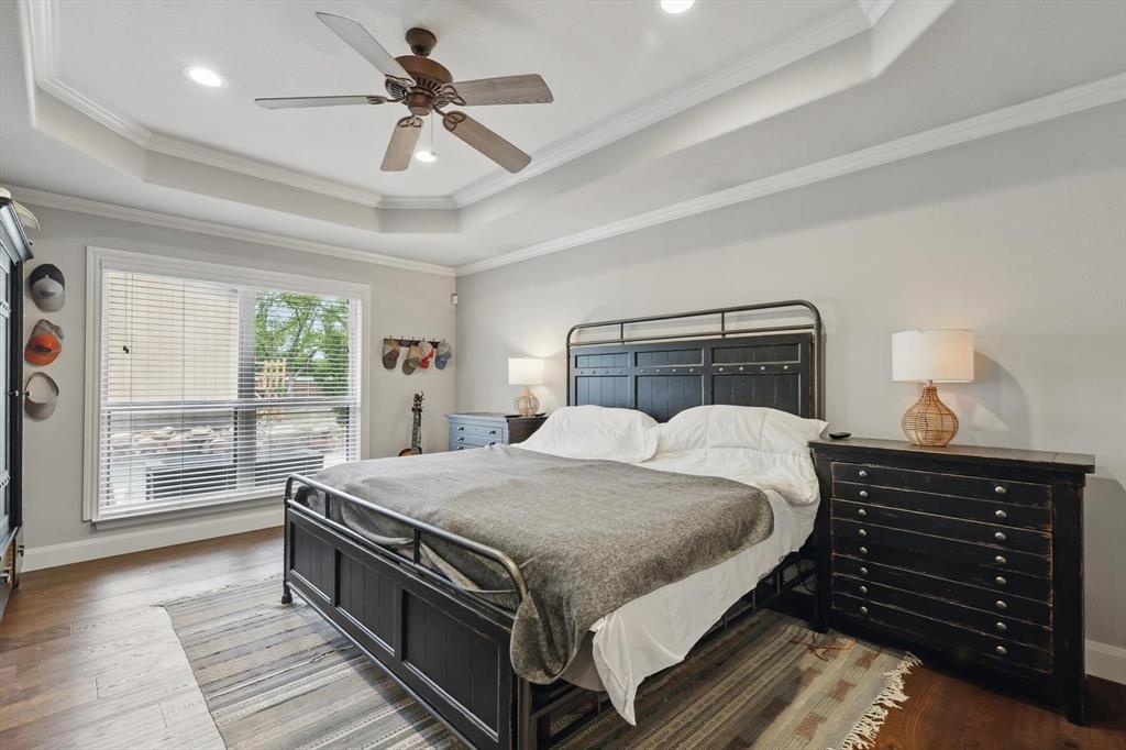 5657 Harmony Ranch Road Aubrey, TX 76227 - Photo 18 of 40 a bedroom with a bed and a chandelier