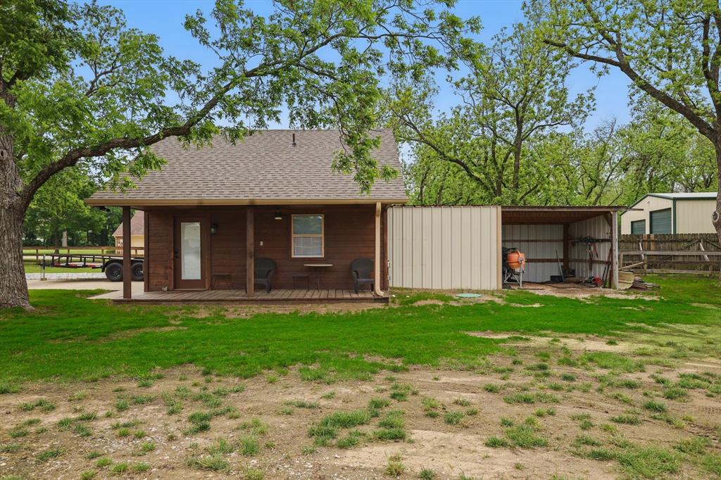 5657 Harmony Ranch Road Aubrey, TX 76227 - Photo 34 of 40 a front view of a house with a garden and trees