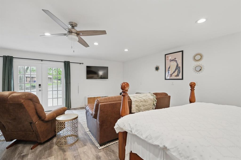 5657 Harmony Ranch Road Aubrey, TX 76227 - Photo 35 of 40 a bedroom with a bed a couch and a flat screen tv