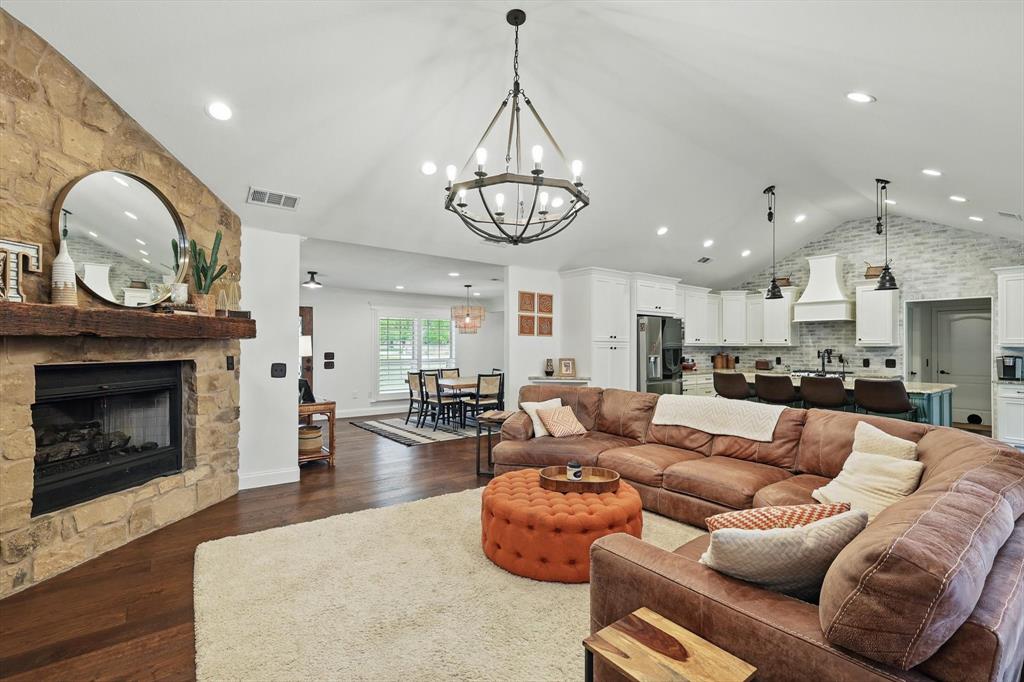 5657 Harmony Ranch Road Aubrey, TX 76227 - Photo 10 of 40 a living room with furniture a fireplace and a chandelier