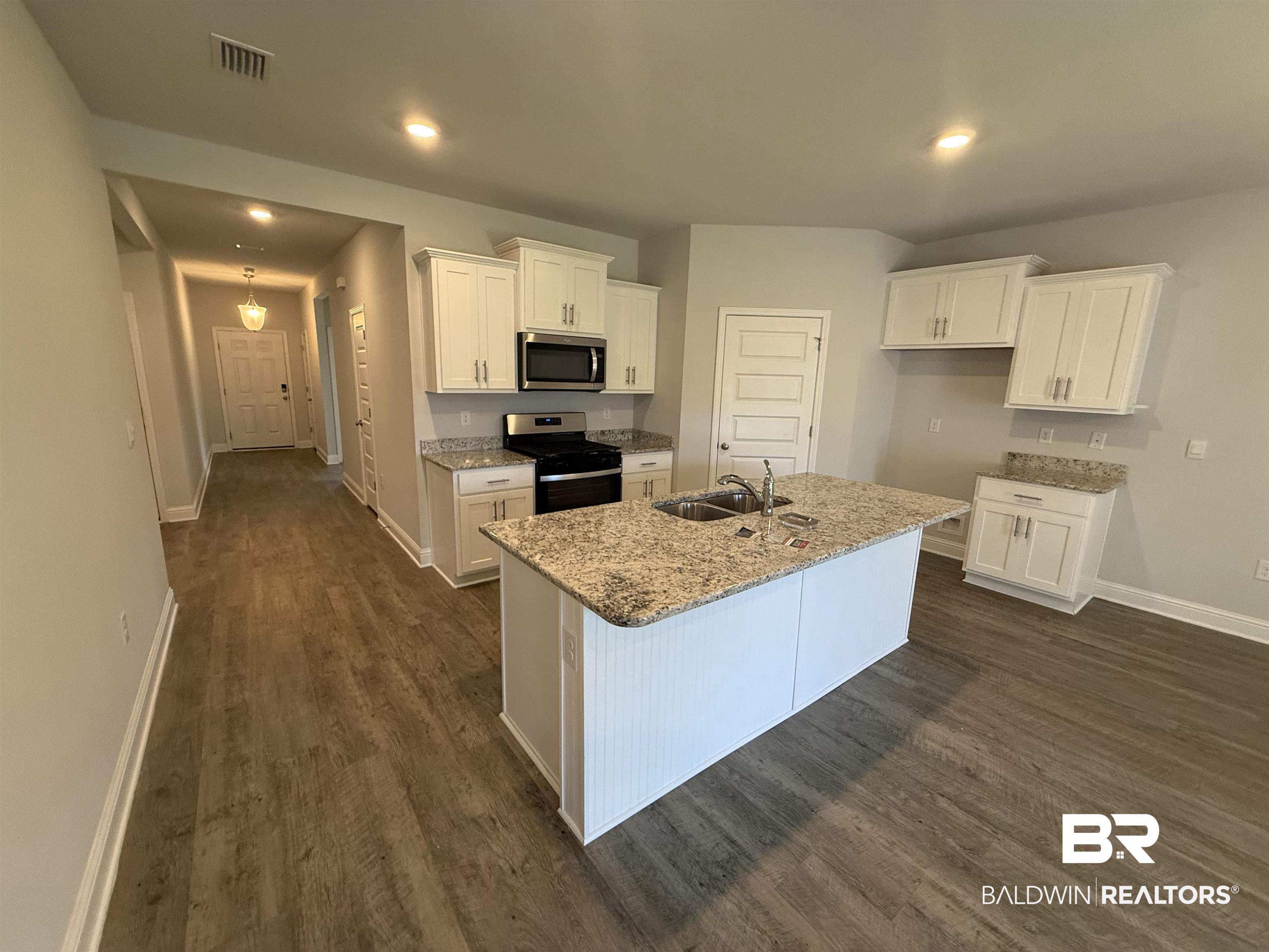 23247 Lieutenant Avenue Foley, AL 36535 - Photo 17 of 47 Modern kitchen featuring white shaker cabinetry, stainless steel appliances, and granite countertops