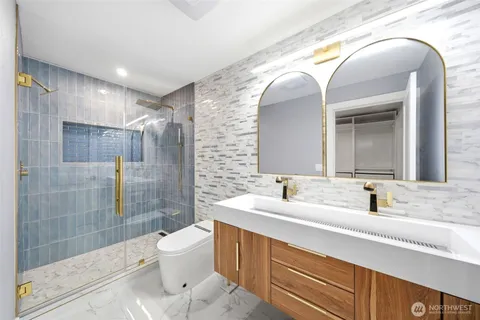 a bathroom with a double vanity sink toilet and shower