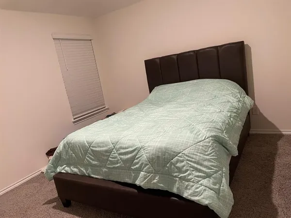 a bed sitting in a bedroom with wooden floor