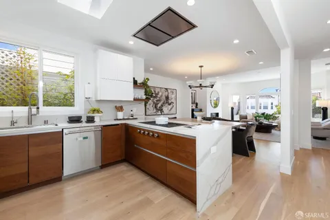 a kitchen with stainless steel appliances granite countertop a stove a sink and a refrigerator
