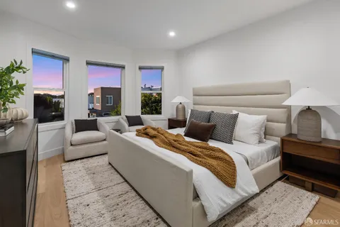a bedroom with a large bed and windows
